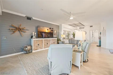 a living room with furniture a flat screen tv and a table