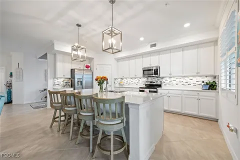 a kitchen with stainless steel appliances granite countertop a sink a stove a microwave a refrigerator and cabinets