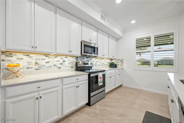 a kitchen with white cabinets and white appliances
