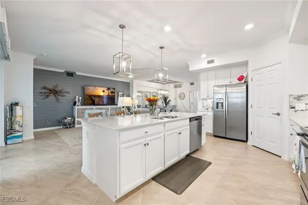 a kitchen with stainless steel appliances kitchen island granite countertop a refrigerator and a stove top oven