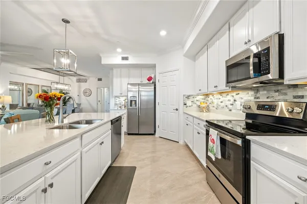 a kitchen with stainless steel appliances granite countertop a sink a stove and a refrigerator