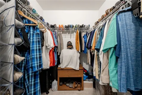 a view of walk in closet with clothes and shoes