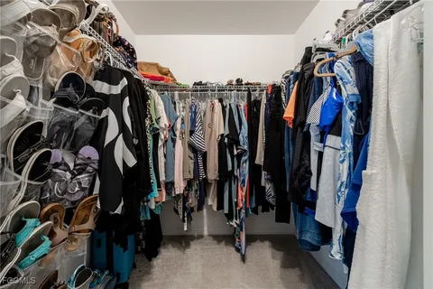 a view of walk in closet with clothes