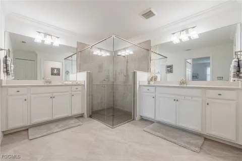 a spacious bathroom with a shower a sink double and mirror