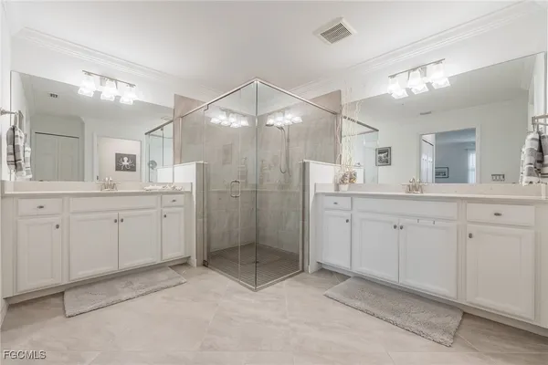 a spacious bathroom with a shower a sink double and mirror