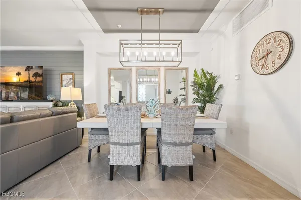 a living room with furniture a chandelier and a flat screen tv