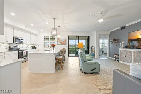 a living room with furniture a flat screen tv and kitchen view