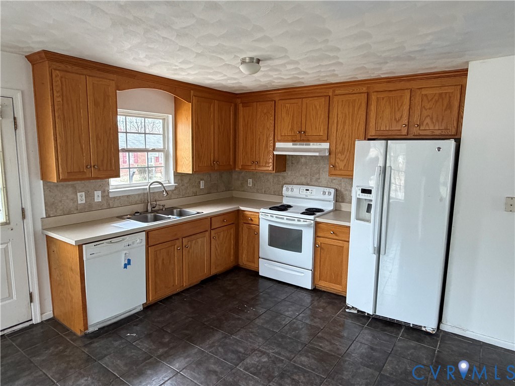 117 Pleasant Spring Avenue Waverly, VA 23890 - Photo 2 of 12 a kitchen with white cabinets and white appliances