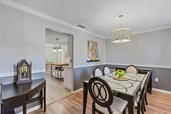 a view of a dining room and kitchen with furniture wooden floor and a rug