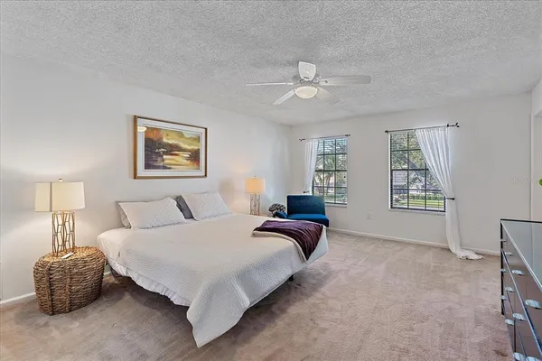a spacious bedroom with a bed and a chandelier