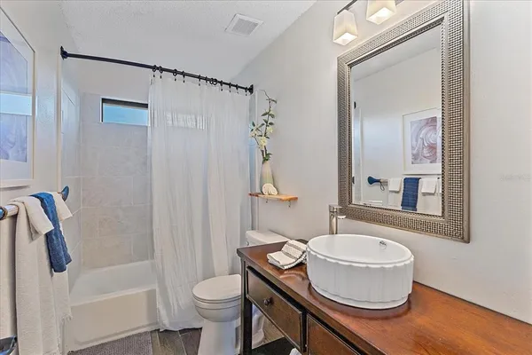 a bathroom with a granite countertop sink toilet a mirror and shower