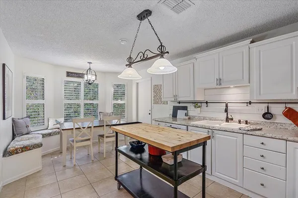 a kitchen with a stove a sink and cabinets