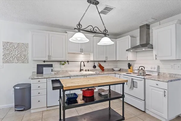 a kitchen with a stove a sink and cabinets