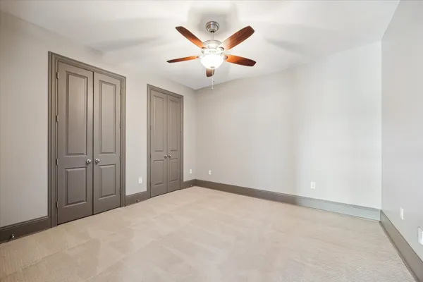 an empty room with closet and ceiling fan
