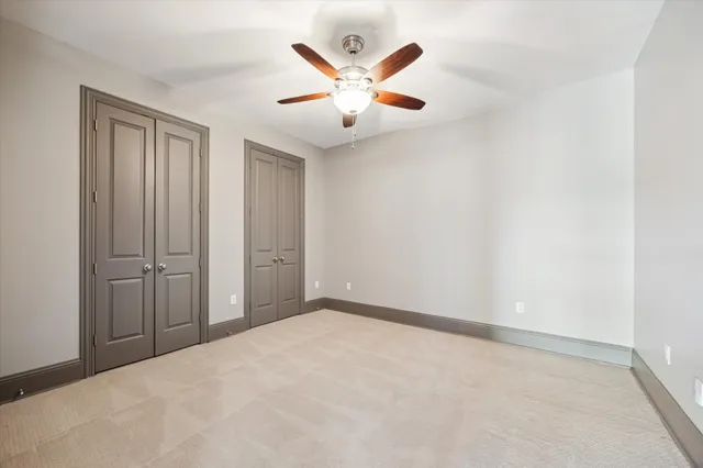 an empty room with closet and ceiling fan