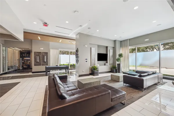 a large living room with stainless steel appliances kitchen island granite countertop a large window and couch