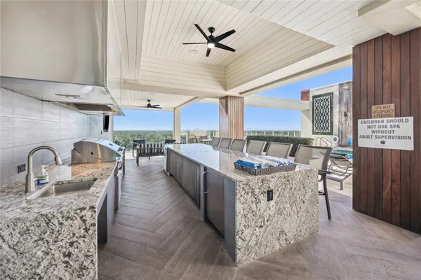 a kitchen with stainless steel appliances granite countertop a stove a sink dishwasher a microwave oven and a dining table with wooden floor