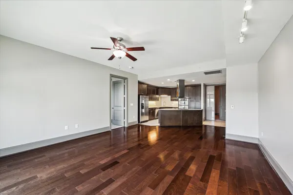 a living room with stainless steel appliances furniture and a kitchen view