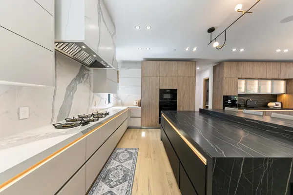 a large kitchen with stainless steel appliances granite countertop a lot of counter space
