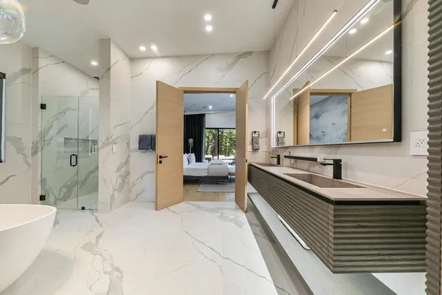 a large white bathroom with a double vanity sink a mirror and a shower