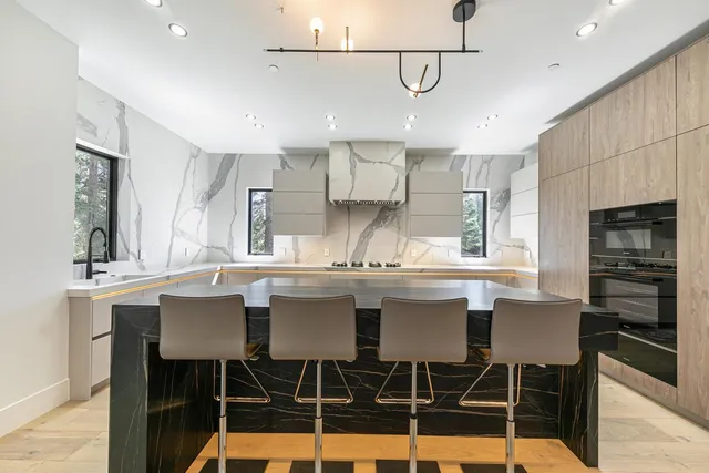 a kitchen with a dining table chairs sink and cabinets
