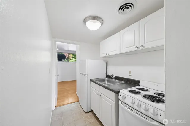 a kitchen with white cabinets and white appliances