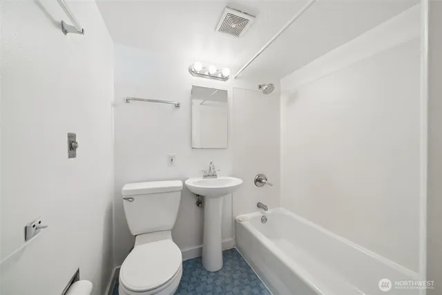 a white toilet sitting next to a bath tub