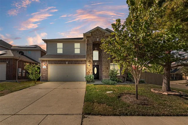 a front view of a house with yard and green space