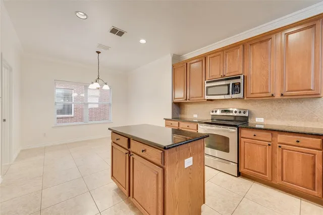 a kitchen with stainless steel appliances granite countertop a stove a sink and a microwave