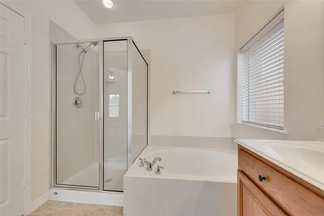 a bathroom with a tub a sink and a window