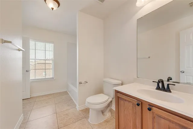 a bathroom with a sink a toilet and a window