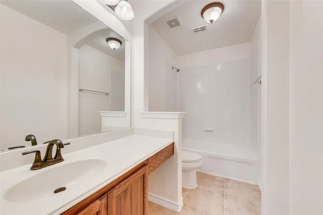 a bathroom with a sink vanity granite tub and a mirror