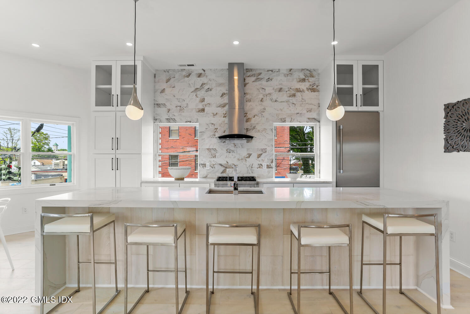 a kitchen with stainless steel appliances granite countertop a stove and white cabinets next to a window