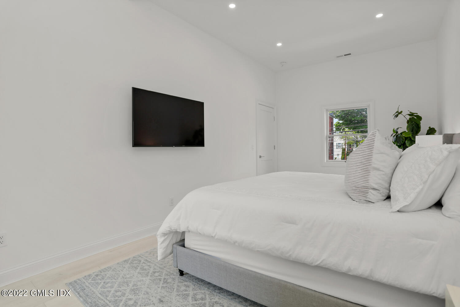 111 Mill Street, Unit PH Greenwich, CT 06830 - Photo 10 of 21 a bedroom with a bed and a flat screen tv