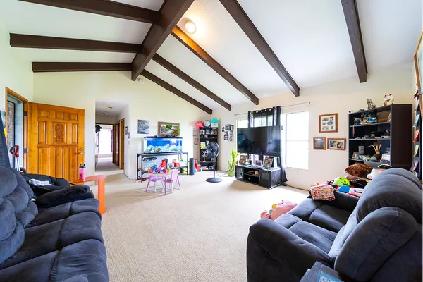 a living room with furniture a flat screen tv and a floor to ceiling window