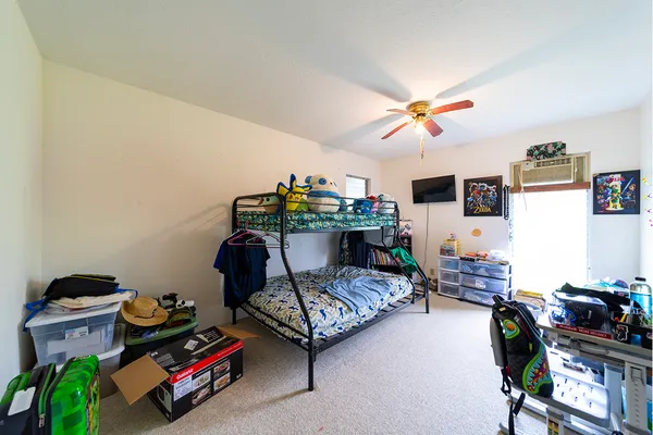 a bedroom with furniture and a chandelier fan