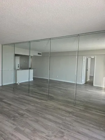 a view of a room with wooden floor