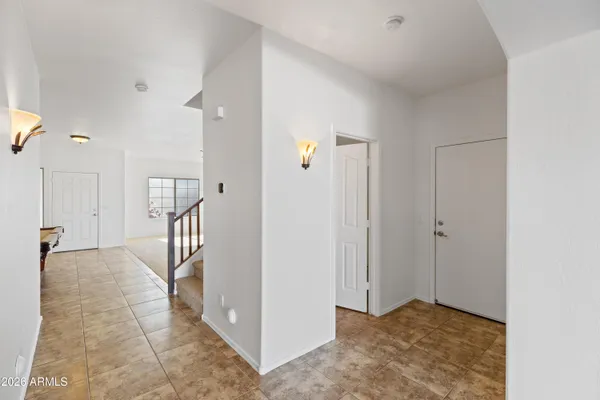a view of a hallway with wooden floor and a bathroom
