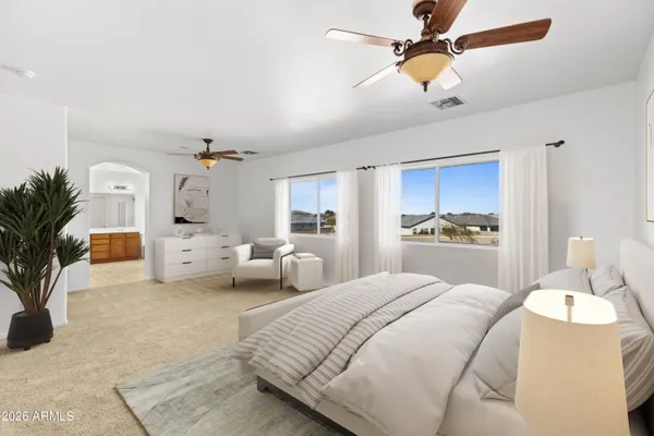 a bedroom with a bed couch and potted plant