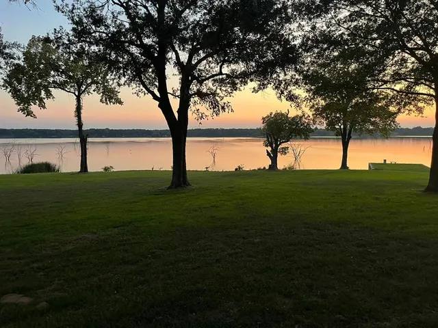 a backyard of a house with lots of green space and garden in back