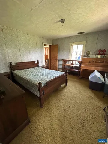 a bed sitting in a room next to a lamp