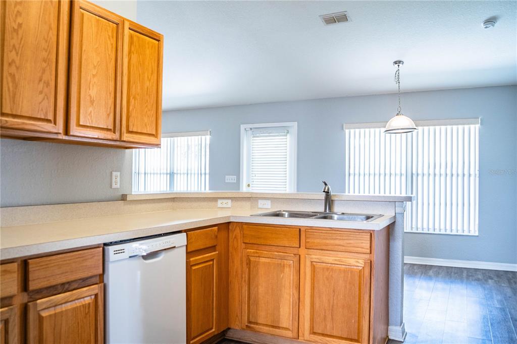 233 Towhee Road Winter Haven, FL 33881 - Photo 25 of 87 a kitchen with stainless steel appliances granite countertop a sink and cabinets with wooden floor