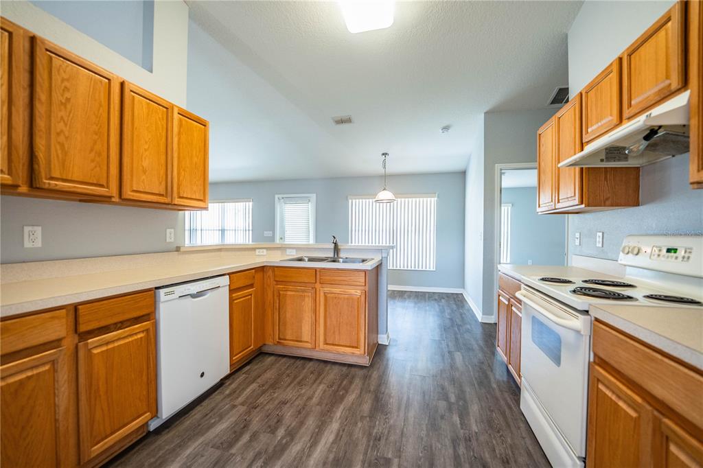 233 Towhee Road Winter Haven, FL 33881 - Photo 28 of 87 a kitchen with stainless steel appliances granite countertop wooden floor sink stove and a granite counter top