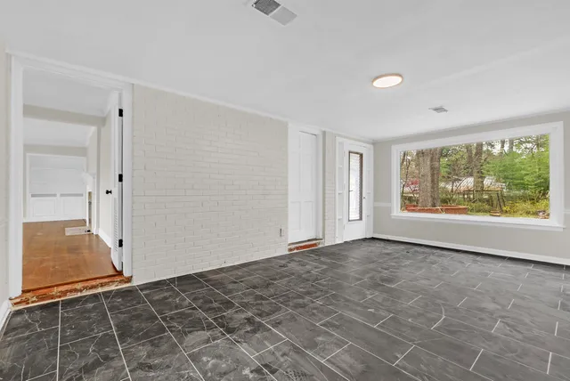 a view of empty room with wooden floor and fireplace