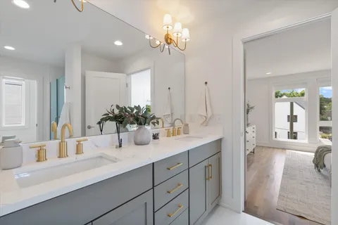a bathroom with a sink double vanity granite tub shower and a mirror