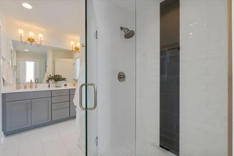 a bathroom with a double vanity sink a mirror a shower and vanity