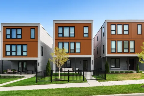 a view of a brick building with many windows and yard