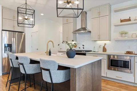 a kitchen with stainless steel appliances a sink a stove a refrigerator and cabinets