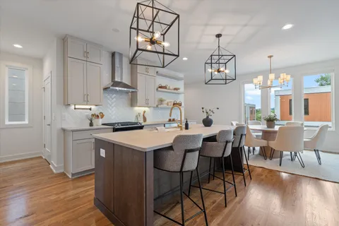 an open kitchen with wooden floor and stainless steel appliances