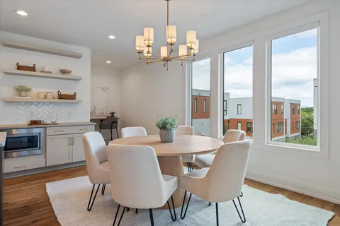 a view of a dining room with furniture large window and wooden floor